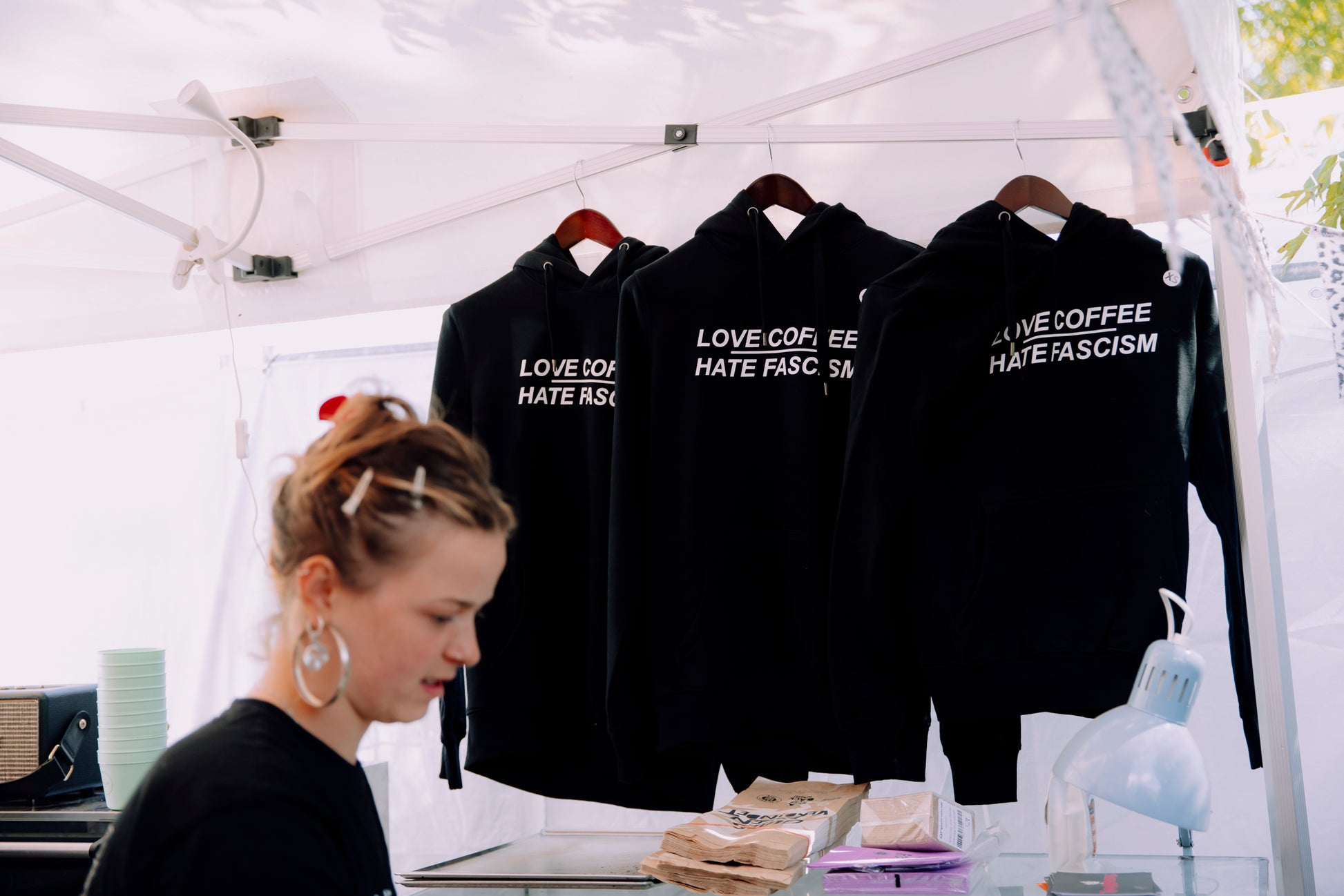 Drei hängende Pullover bei "Jamel rockt den Förster 2025". Marieke ist im Vordergrund zu sehen.